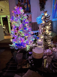 a bottle of water sits on a table next to a christmas tree with purple lights