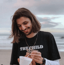 a man wearing a black shirt that says " the child "