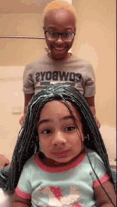 a woman is putting a green wig on a little girl .