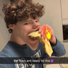 a boy with curly hair is eating a sandwich with the caption the hoes ain t ready for this