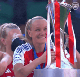a woman is holding a trophy that says arsenal