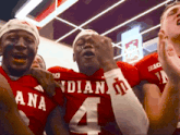a group of football players wearing red uniforms with the number 4 on them