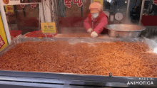 a woman in a pink jacket is cooking noodles in front of a sign that says ' made in animotica '