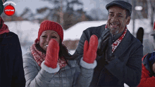 a man and a woman wearing red mittens are standing in the snow with a lifetime logo in the background