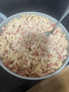 a bowl of macaroni salad with tomatoes and cheese