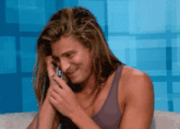 a woman with long hair is smiling while talking on a phone