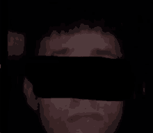 a close up of a man 's face with a black covering over his eyes