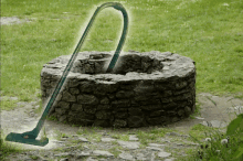 a vacuum cleaner is cleaning a stone well in a yard