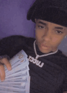 a young man is holding a bunch of money in his hands .