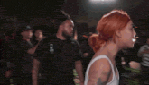 a woman in a white tank top is being punched by a man