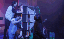 a group of people are standing around a tetris shaped box