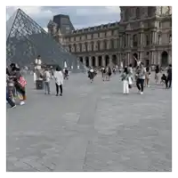 a group of people are walking in front of a pyramid