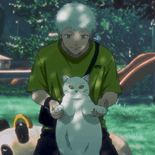 a man in a green shirt holds a white cat on his lap