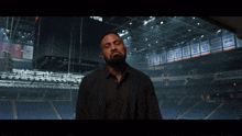 a man stands in front of a stadium with the words " i 'm ready for whatever comes " above him