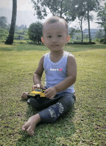 a baby wearing a blue tank top with baby g on it