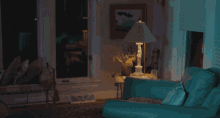 a living room with a blue couch a lamp and a picture on the wall
