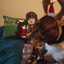 a dog wearing a reindeer headband looks at a waiting for santa paws pillow