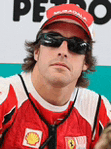 a close up of a man wearing sunglasses and a red hat