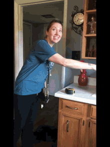 a woman wearing a blue shirt that says ' i love you ' on it stands in front of a clock