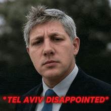 a man in a suit and tie with the words " tel aviv disappointed " behind him