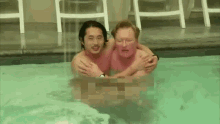 two men are hugging each other in a swimming pool .