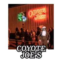 a man in a suit stands in front of a coyote joes sign