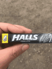 someone is holding a pack of halls strong-lyptus