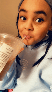 a young girl drinking through a straw from a cup that says ' kendall ' on the label