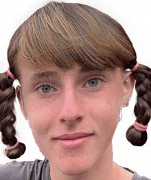 a close up of a woman 's face with pigtails and a ponytail .