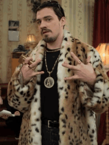 a man wearing a leopard print coat and a necklace with the letter a on it