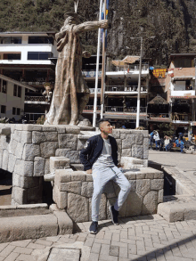 a man wearing a jacket that says ' abercrombie & fitch ' on it stands in front of a statue