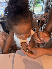 a little girl eating an oyster with a toothpick