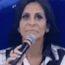 a woman is singing into a microphone while making a funny face .