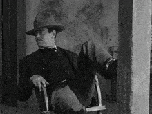 a man in a cowboy hat sits in a chair
