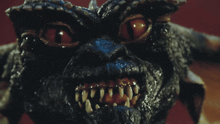 a close up of a gremlin 's face with bright red eyes