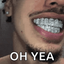 a close up of a man 's mouth with a beard and grills on his teeth .