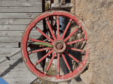 a red wagon wheel with a green zucchini sticking out of the center