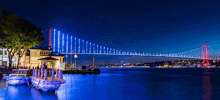 a bridge over a body of water at night with blue lights