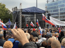 a crowd of people are gathered in front of a stage with flags and a banner that says ' slovakia '