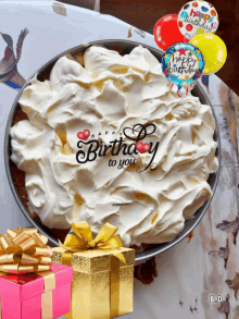 a cake with whipped cream and balloons that say happy birthday to you