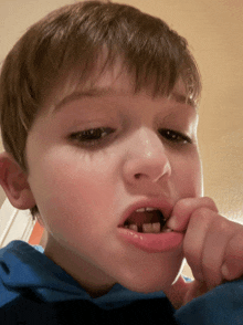 a close up of a young boy 's face with a missing tooth in his mouth