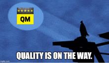 a silhouette of batman standing on top of a building with the words quality is on the way