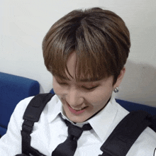 a young man in a white shirt and black tie smiles