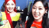 two girls are smiling for a picture and one of them has a foreign language written on her hair