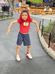 a young boy wearing a red shirt with the lightning bolt on it