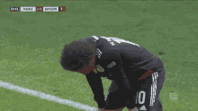 a soccer player with the number 10 on his jersey is kneeling down