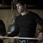 a man in a black shirt is standing in a dark room