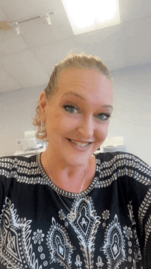 a smiling woman wearing a black and white shirt