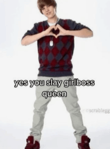 a young man is making a heart shape with his hands and says yes you slay girl boss queen