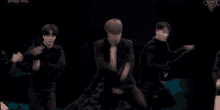 a group of men are dancing in a dark room .